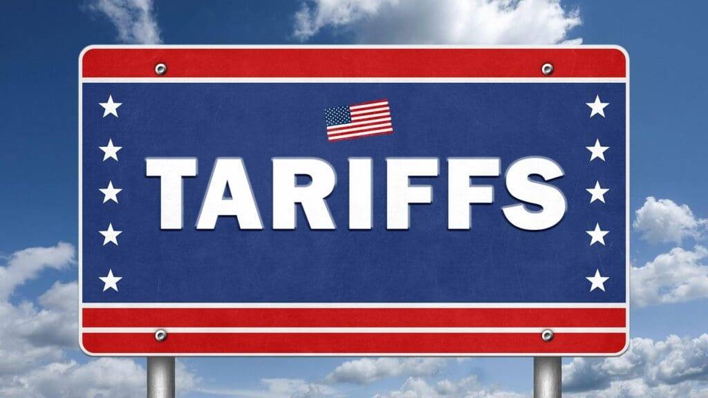 A blue sign with the word 'TARIFFS' in large white letters and an American flag above it.